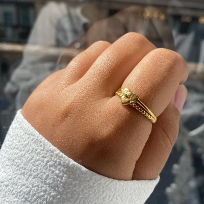 Mão com anel dourado estilo corrente com figura decorativa