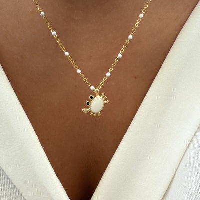 Colar dourado com pérolas e pendente caranguejo branco