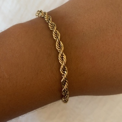 Pulseira dourada em espiral no pulso