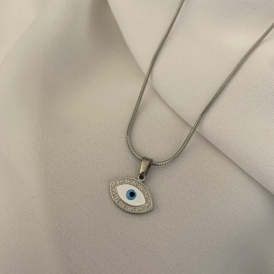 Colar prateado com pingente em forma de olho sobre tecido branco
