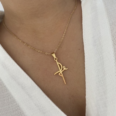 Colar dourado com pendente estilizado usado no pescoço