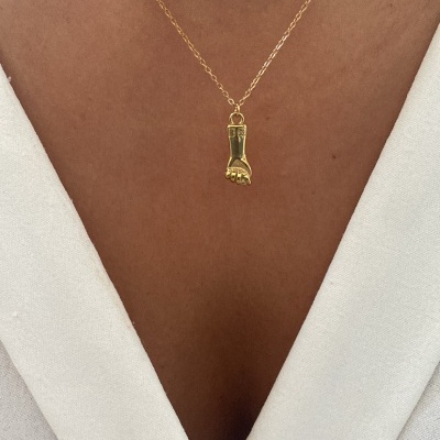 Colar dourado com pendente em forma de punho aberto