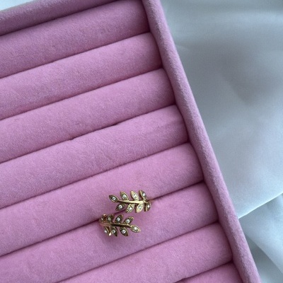 Brincos em forma de folhas douradas numa caixa de veludo rosa