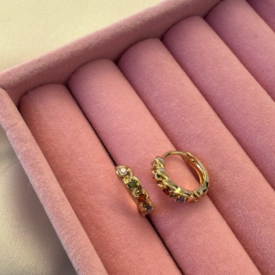 Brincos de argola dourados com pedras coloridas numa caixa rosa de veludo