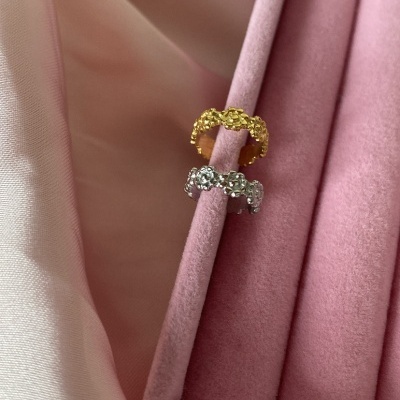 Dois anéis texturizados dourado e prateado num suporte de veludo rosa