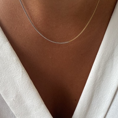 Colar bicolor fino num tecido branco