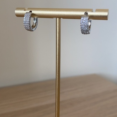 Brincos de argola prateados com pedras brilhantes em suporte dourado