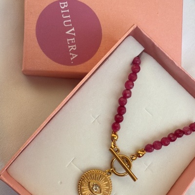 Colar com contas vermelhas e pendente dourado numa caixa rosa BIJUVERA