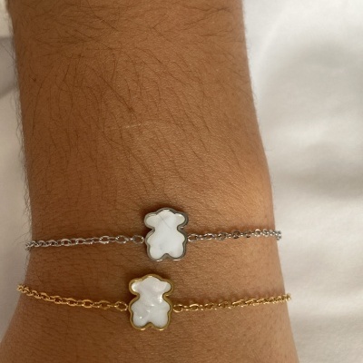 Pulseiras prateada e dourada com pendente de ursinho branco
