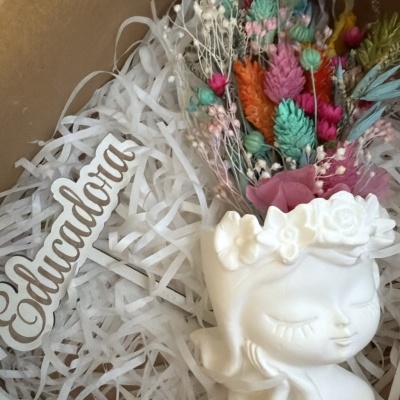 Vaso decorativo rosto branco com flores secas coloridas numa caixa de cartão