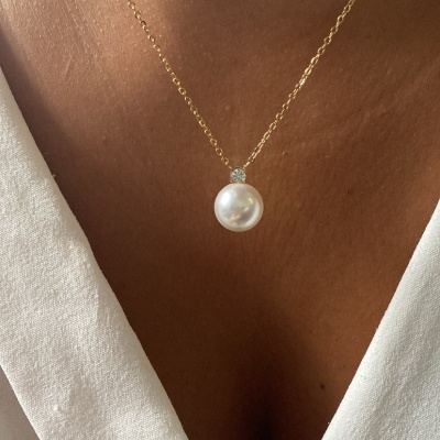 Colar delicado com pérola e brilhante em peito com camisa branca