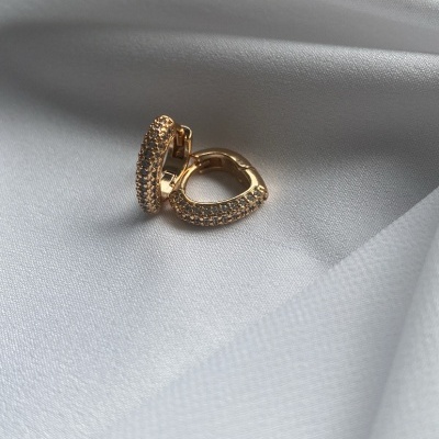 Brincos dourados com cristais sobre tecido branco