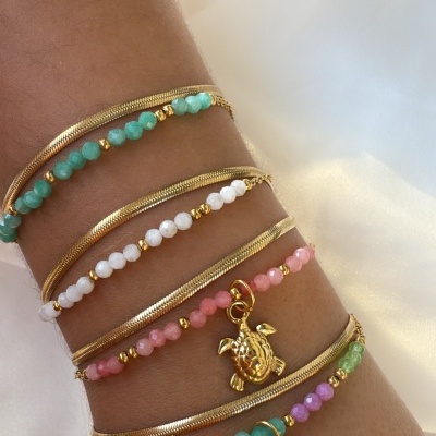 Pulseiras coloridas com pingentes de tartaruga e estrela do mar num pulso