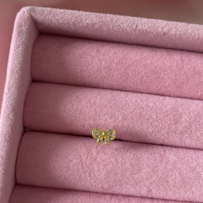 Anel dourado com laço com pedras em caixa de veludo rosa