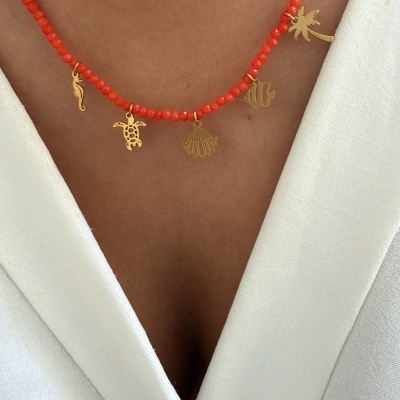 Colar com contas vermelhas e pendentes dourados em forma de animais e plantas