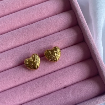brincos dourados em forma de coração numa caixa de veludo rosa