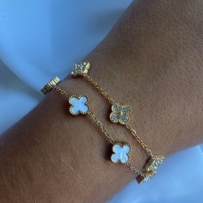 Pulseira dourada com flores em madrepérola no pulso