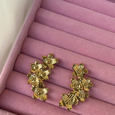 Brincos dourados com design de flores em caixa de veludo rosa