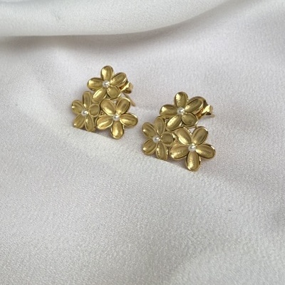 Brincos dourados em forma de flores com pequenas pedras no centro
