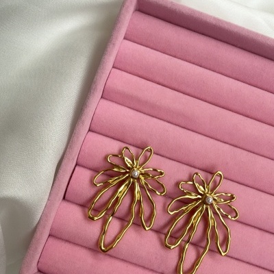 Brincos dourados em forma de flores com pérolas em caixa rosa