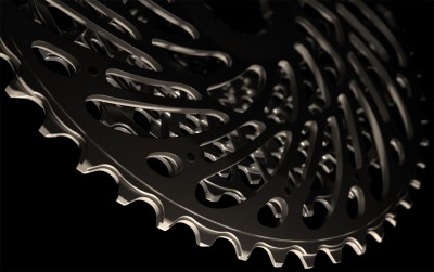 Cassete de bicicleta metálico preto com dentes e furos em fundo preto