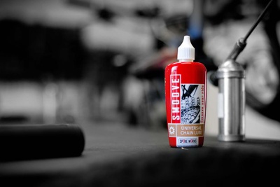 Frasco vermelho de lubrificante para corrente de bicicleta com tampa branca