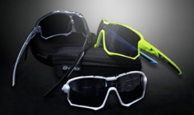 Três óculos de sol desportivos com armações coloridas e estojo preto.