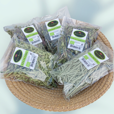 Pacotes de ervas secas em sacos plásticos transparentes numa cesta de palha