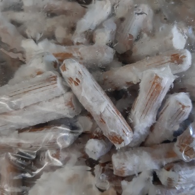 Gravetos finos cobertos de resina branca dentro de saco plástico translúcido