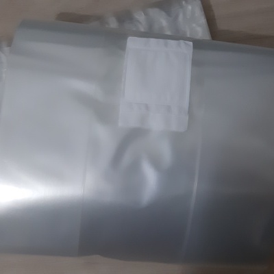 Sacolas plásticas transparentes com etiqueta branca numa mesa de madeira