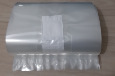 Rolo de saco plástico transparente e brilhante sobre superfície de madeira