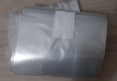 Sacolas plásticas transparentes com etiqueta branca numa mesa de madeira