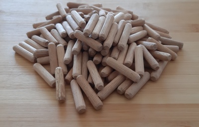 Cavilhas de madeira claras corrugadas sobre mesa de madeira