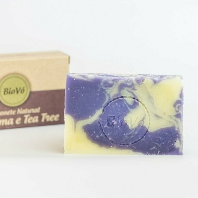 Sabonete natural amarelo e roxo com selo e caixa de papelão ao fundo