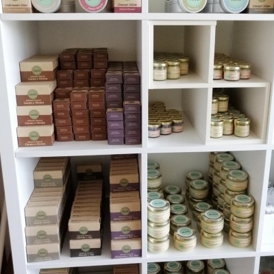 Prateleira branca com produtos cosméticos em embalagens de papelão e frascos