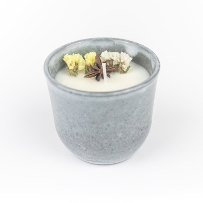 Vela decorativa em copo cinza com flores secas