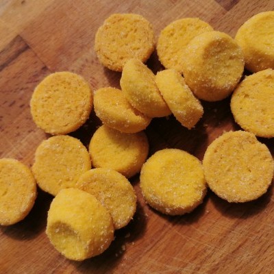 Pequenos pastéis amarelos sobre tábua de madeira