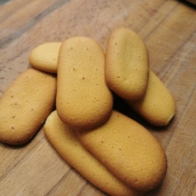 Biscoitos dourados alongados sobre tábua de madeira