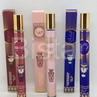 Três fragrâncias em frascos finos com tampa dourada e embalagens coloridas (vinho, rosa, azul)
