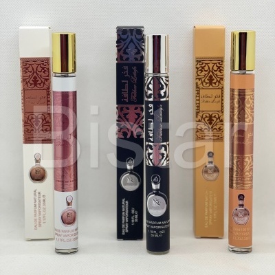 Três frascos de perfume spray com tampa dourada e caixas decoradas em rosa, preto e bege sobre fundo branco.