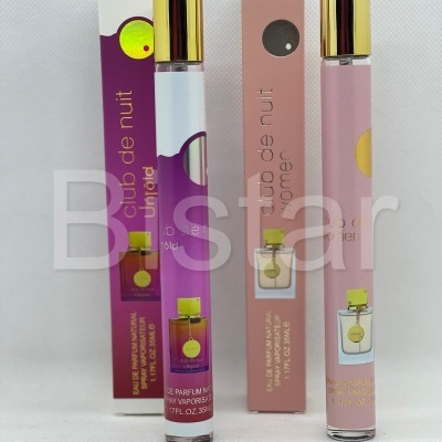 Dois frascos de perfume Club de nuit com embalagens rosa e roxa e frascos com tampas douradas