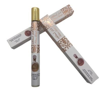 Perfume em frasco cilíndrico com tampa dourada e embalagem com padrão dourado