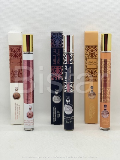 Três frascos de perfume spray com tampa dourada e caixas decoradas em rosa, preto e bege sobre fundo branco.