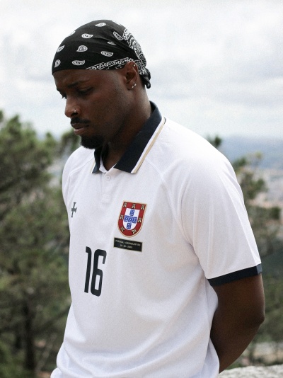 Homem com bandana preta e t-shirt branca com número 16 e emblema de Portugal