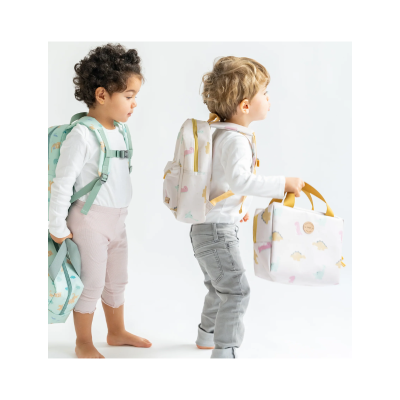 Duas crianças com mochilas infantis estampadas com dinossauros em fundo branco