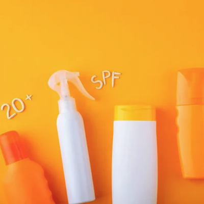 Frascos de protetor solar e texto 20+ SPF sobre fundo laranja