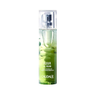 Frasco de perfume Caudalie Fleur de Vigne com líquido verde e cápsulas visíveis no interior.