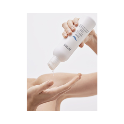 Pessoa a verter líquido de garrafa branca BABE LABORATORIOS