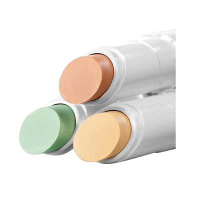 Bastões de corretor em verde, castanho e bege com embalagens brancas.