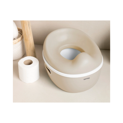 Penico infantil bege com tampa branca junto a rolo de papel higiénico e cesto de tecido